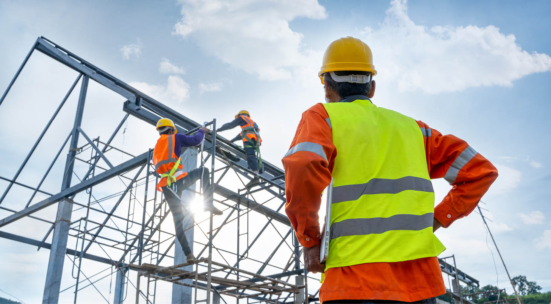 Engineer technician watching team of workers on high steel platform,Engineer technician Looking Up and Analyzing an Unfinished Construction Project 