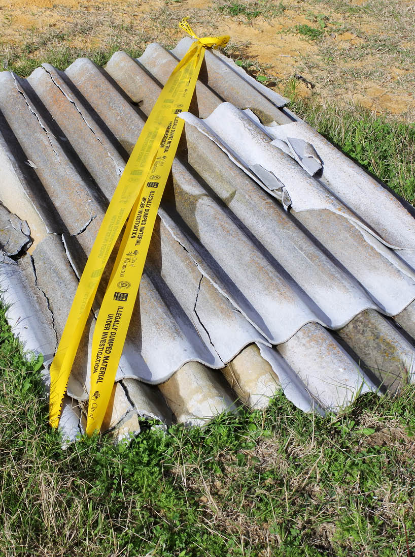 PERTH, WA -  JULY 07 2021: Illegal dumping of Asbestos Cement Corrugated Roof Wall and Fence Sheeting Asbestos is a dangerous substance and should be avoided