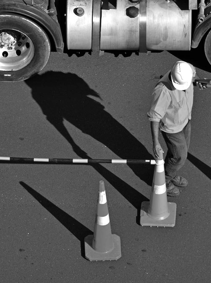 Unrecognizable Road construction worker on city street during traffic lines markings works 