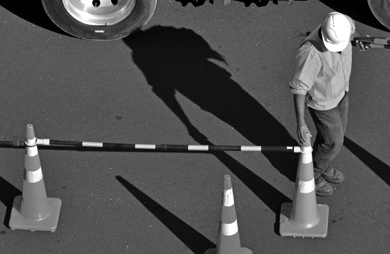 Unrecognizable Road construction worker on city street during traffic lines markings works 