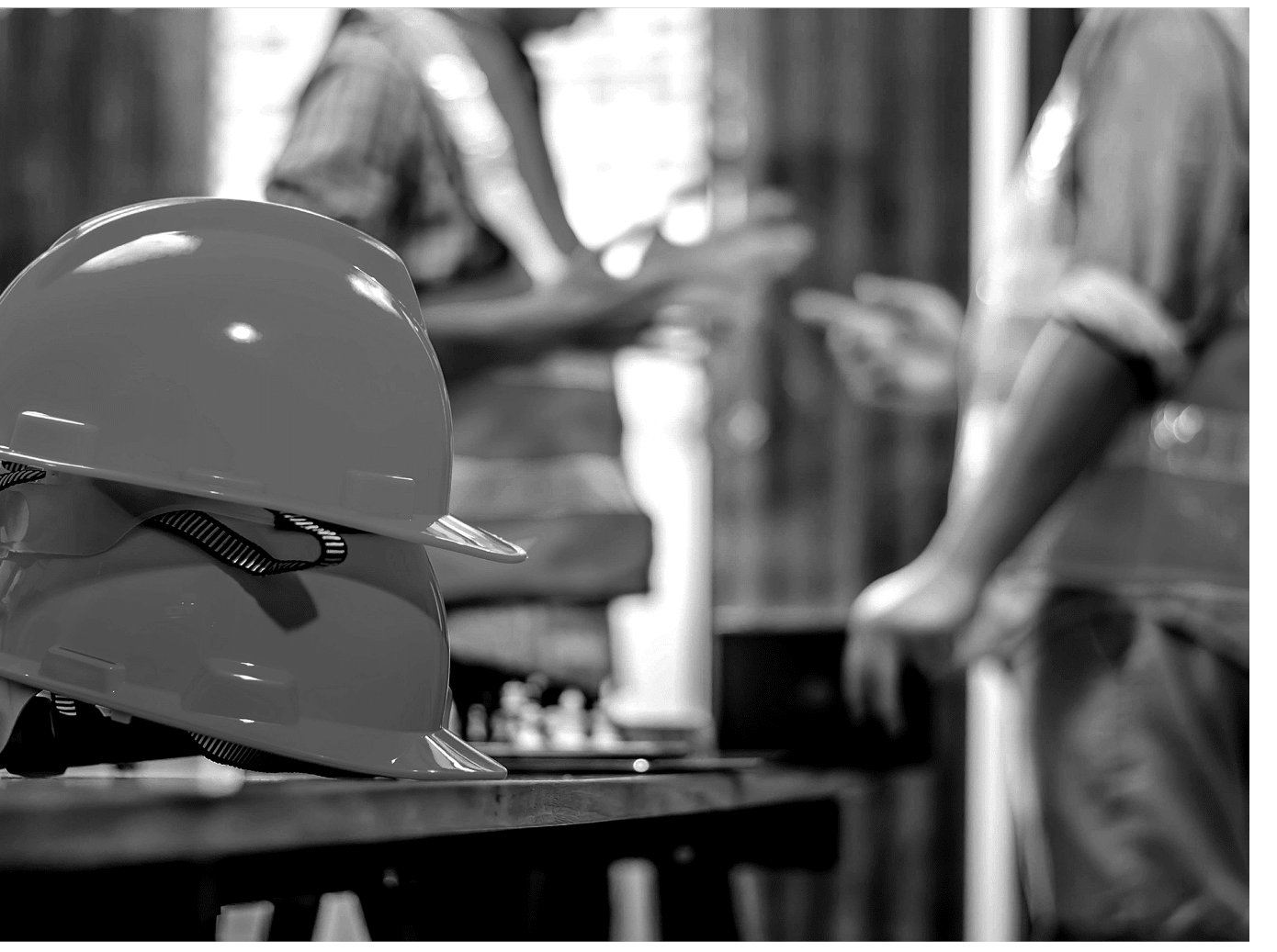 Yellow hard safety helmet hats for safety project of workman as engineer or worker, Two construction engineers talking at construction site with blueprint on table 