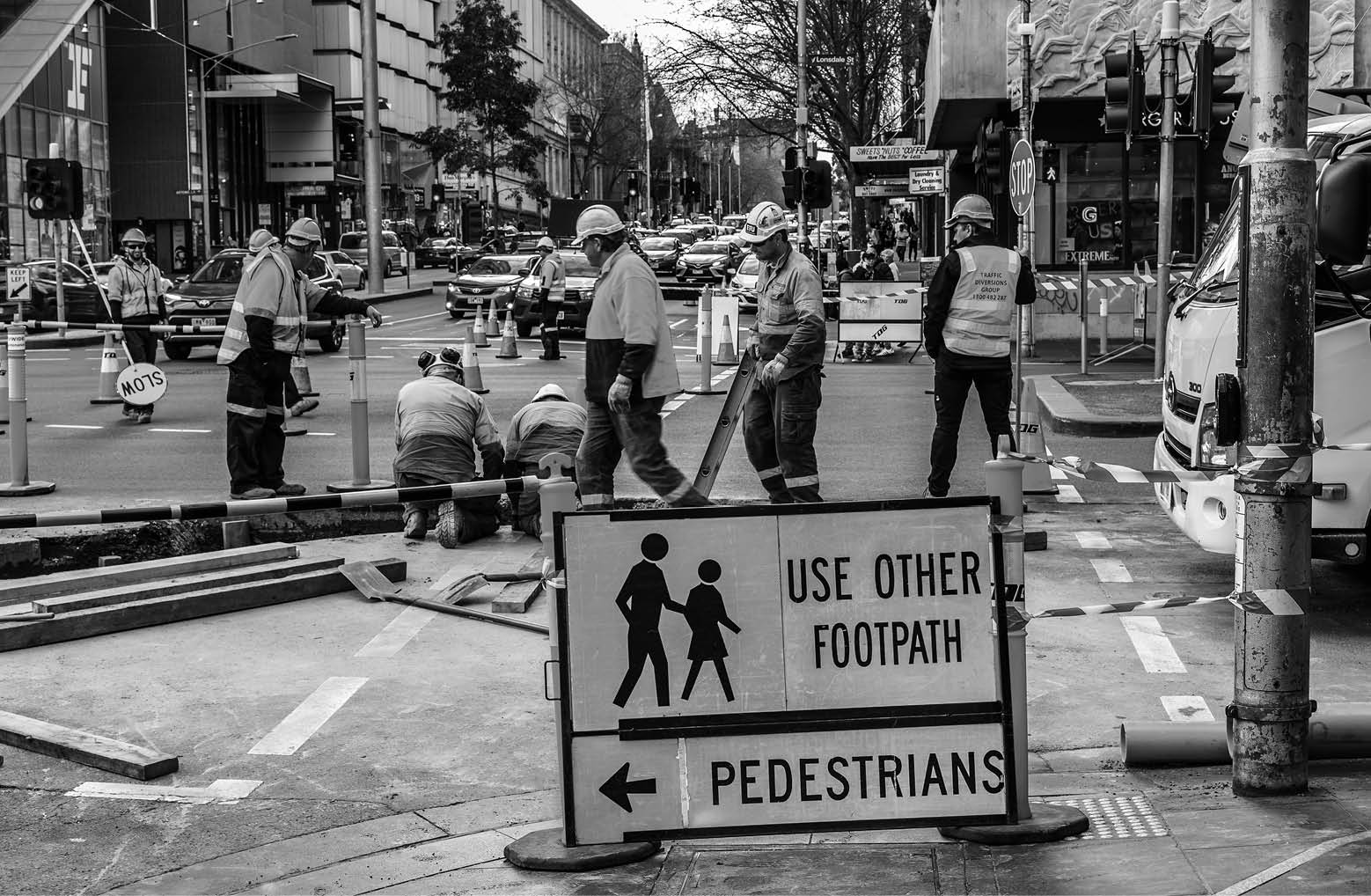 Melbourne, Victoria, Australia, September 8, 2018: Many road workers in orange vests are working on a busy inner city street 