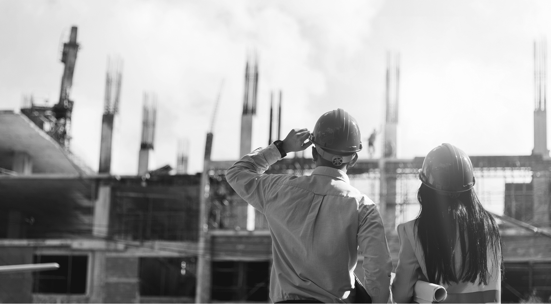 Asian man civil engineer and woman architect wearing blue safety helmet meeting at contruction site 