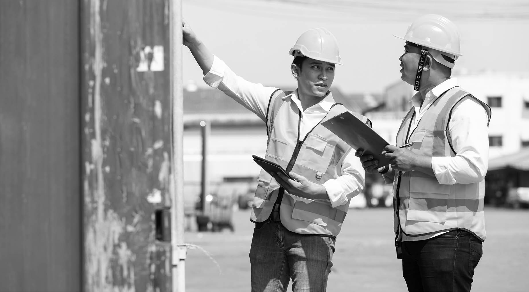 factory workers or engineers talking and exploring container in factory workshop