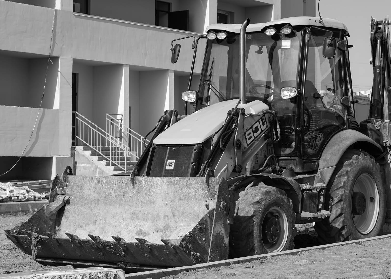 Kharkiv, Ukraine, March 29, 2020: Excavator JCB parked outside  The dirty yellow tractor at the construction site  European vehicle, bulldozer with bucket  Illustrative editorial 