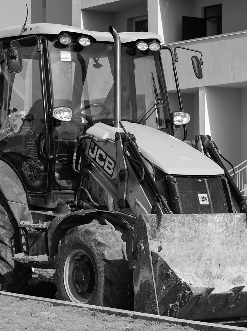 Kharkiv, Ukraine, March 29, 2020: Excavator JCB parked outside  The dirty yellow tractor at the construction site  European vehicle, bulldozer with bucket  Illustrative editorial 